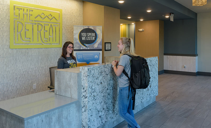 Two people talking in leasing office of The Retreat